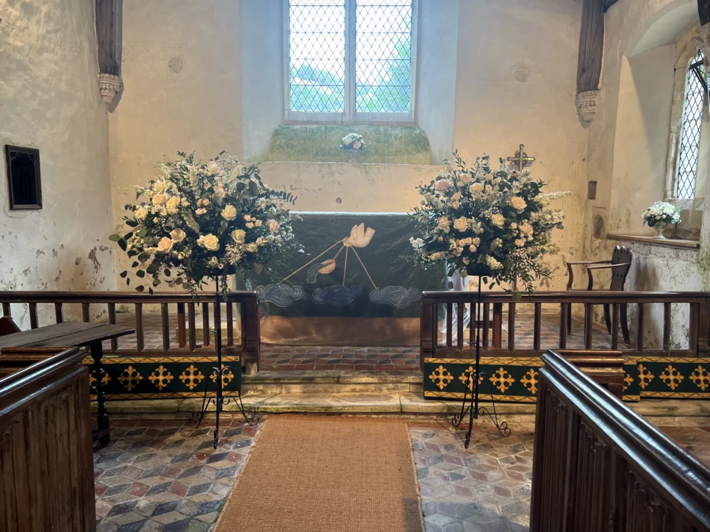 White and blush pink pedestal flower displays for an elegant church wedding