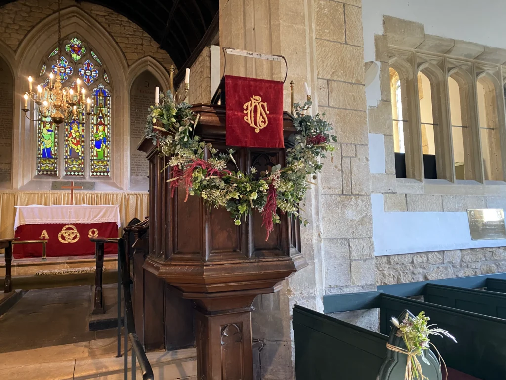 Natural pulpit garland with fresh seasonal flowers and trailing foliage