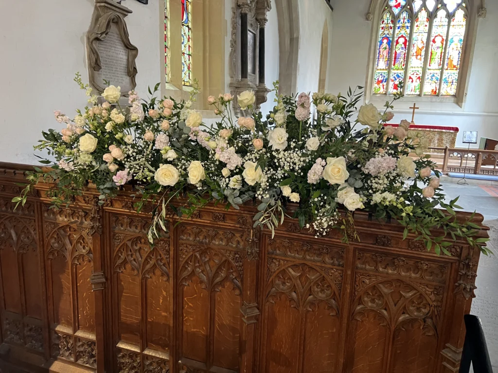 Natural floral installation across the front of the church with seasonal flowers and greenery