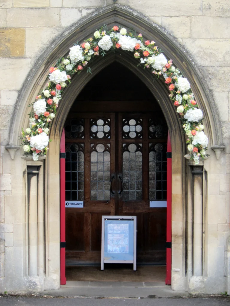 Coral and white floral church archway for wedding ceremony entrance