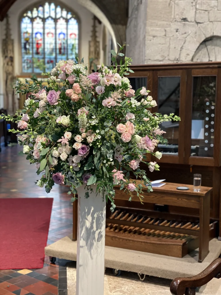 Natural pedestal arrangement with roses, eustoma and eucalyptus foliage