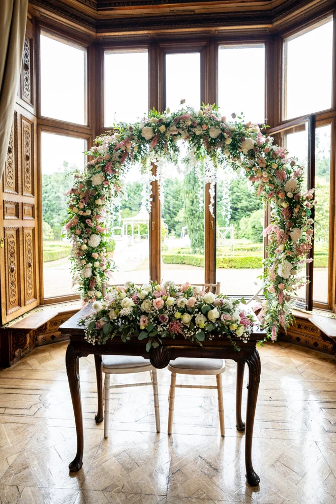 Statement floral moon gate with coordinating ceremony table arrangement at Manor by the Lake