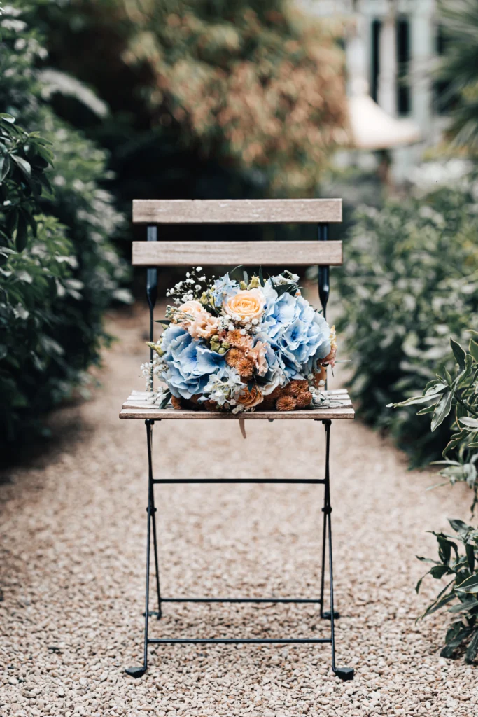 Wedding florals featuring blue hydrangeas and peach roses at The Matara Centre, Tetbury
