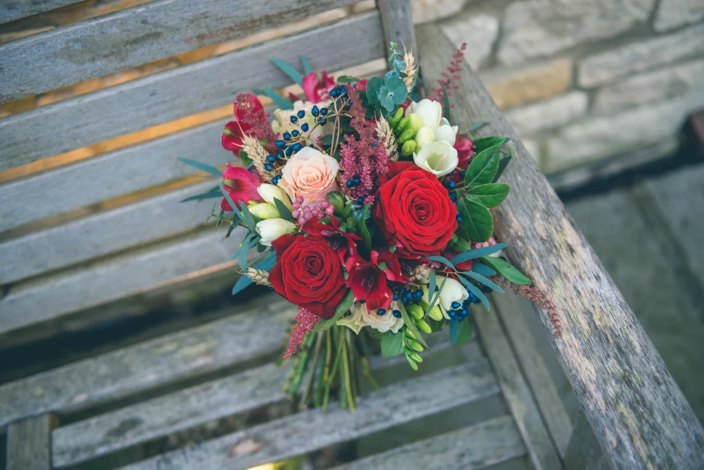 Winter wedding bouquet featuring red and peach floral details