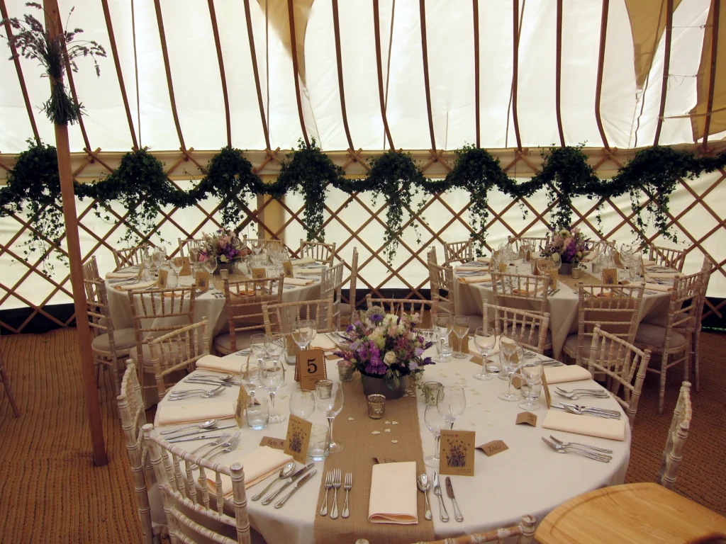 Country garden table flowers with trailing ivy dressing a yurt wedding in the Cotswolds