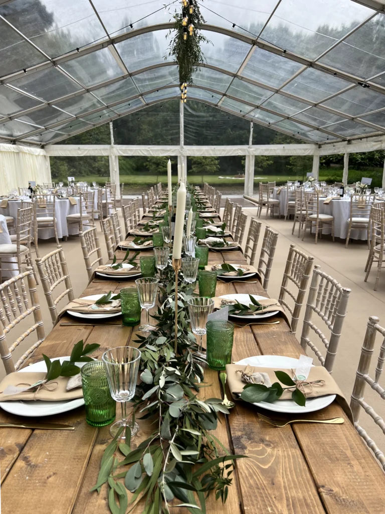 Trailing foliage garlands creating a fresh green look inside a Cotswold garden marquee