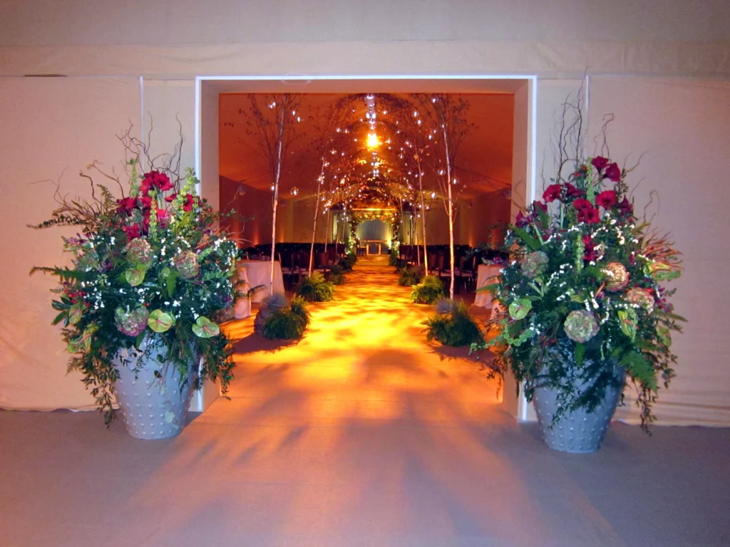 Enchanted forest themed wedding flowers decorating the entrance to a marquee wedding venue in the Cotswolds