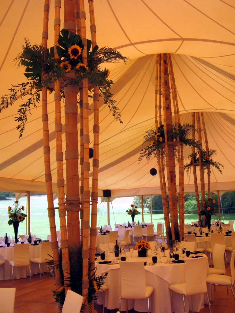 Sunflowers and tropical foliage decorating a wedding marquee for a bright and colourful Cotswolds celebration