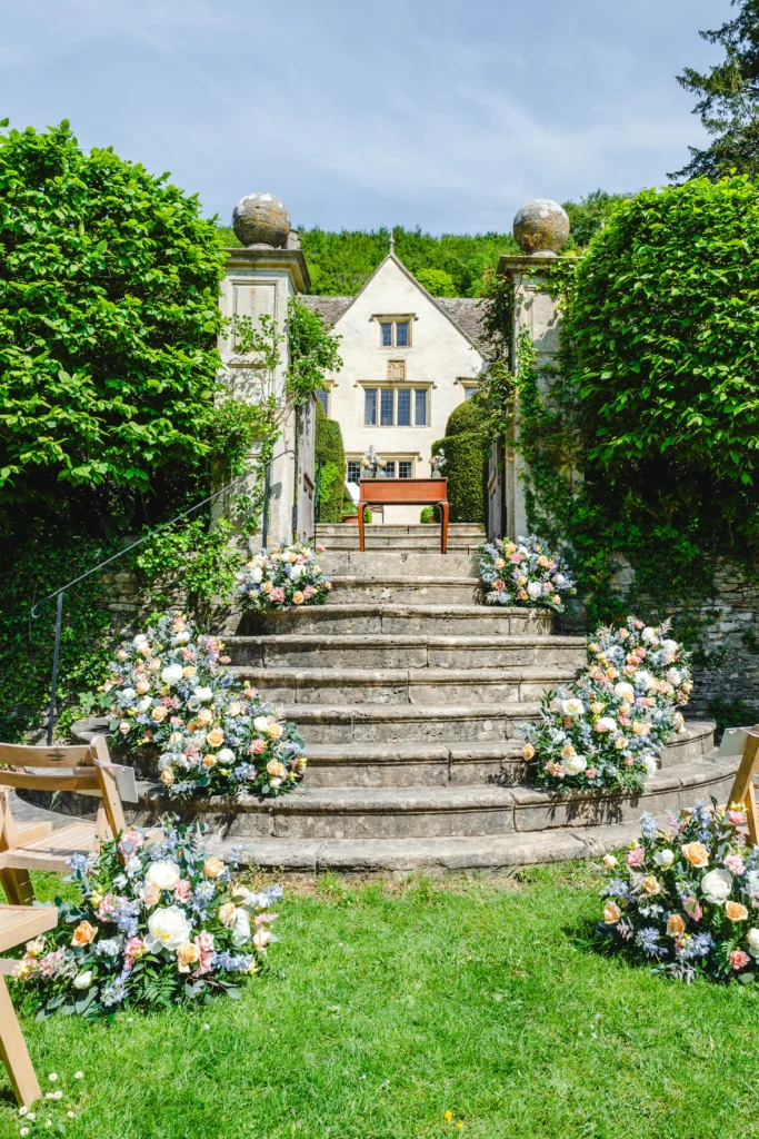 Delicate pastel floral staircase arrangement at Owlpen Manor